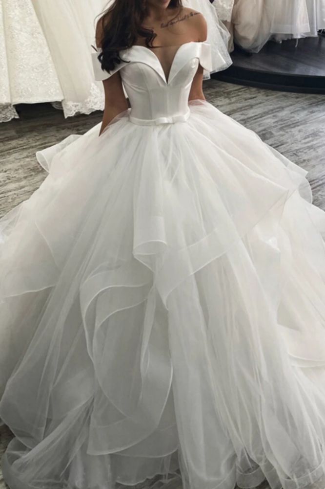 Elegante vestido de novia con hombros descubiertos y capas hinchadas